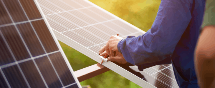 man working on a solar power mounting with pencil